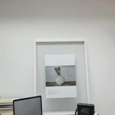 Laptop with film camera and piles of negative tapes arranged on desk